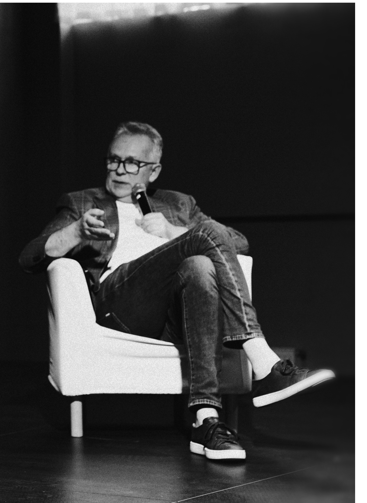 Man with microphone in white chair